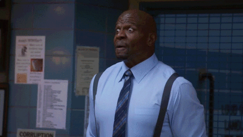 A gif with the cast of Brooklyn 99 raising their arms and celebrating while mouthing YES
