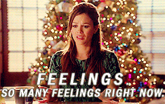 A woman in front of a Christmas tree waves her hands with the caption "Feelings. So many feelings right now."
